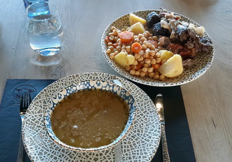 Cocido madrileño servido en sus vuelcos: sopa y garbanzos con carne y verdura