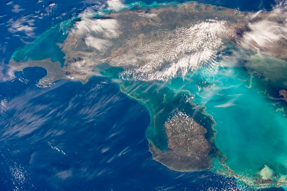 Vista aérea desde la Estación Espacial Internacional del contraste entre el agua turquesa somera y el azul profundo, cerca de Cuba