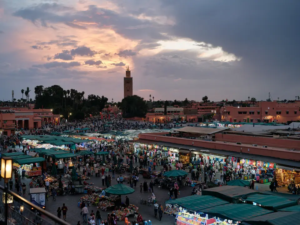 La plaza Jemaa el-Fnaa de Marrakech al atardecer, con la torre de la mezquita Koutoubia al fondo