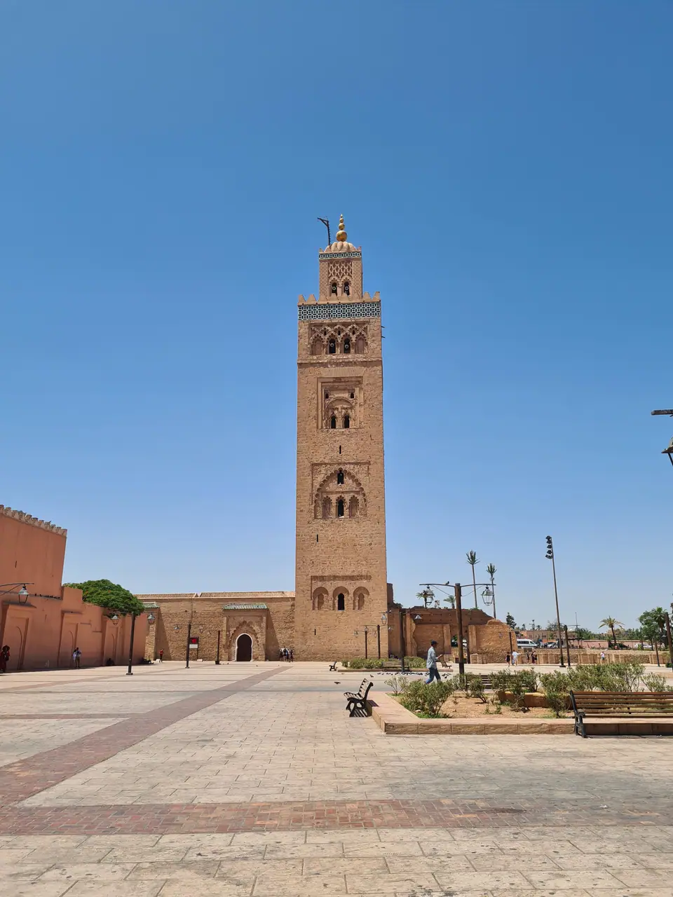 El alminar de la mezquita Koutoubia en Marrakech, con la plaza y cielo despejado