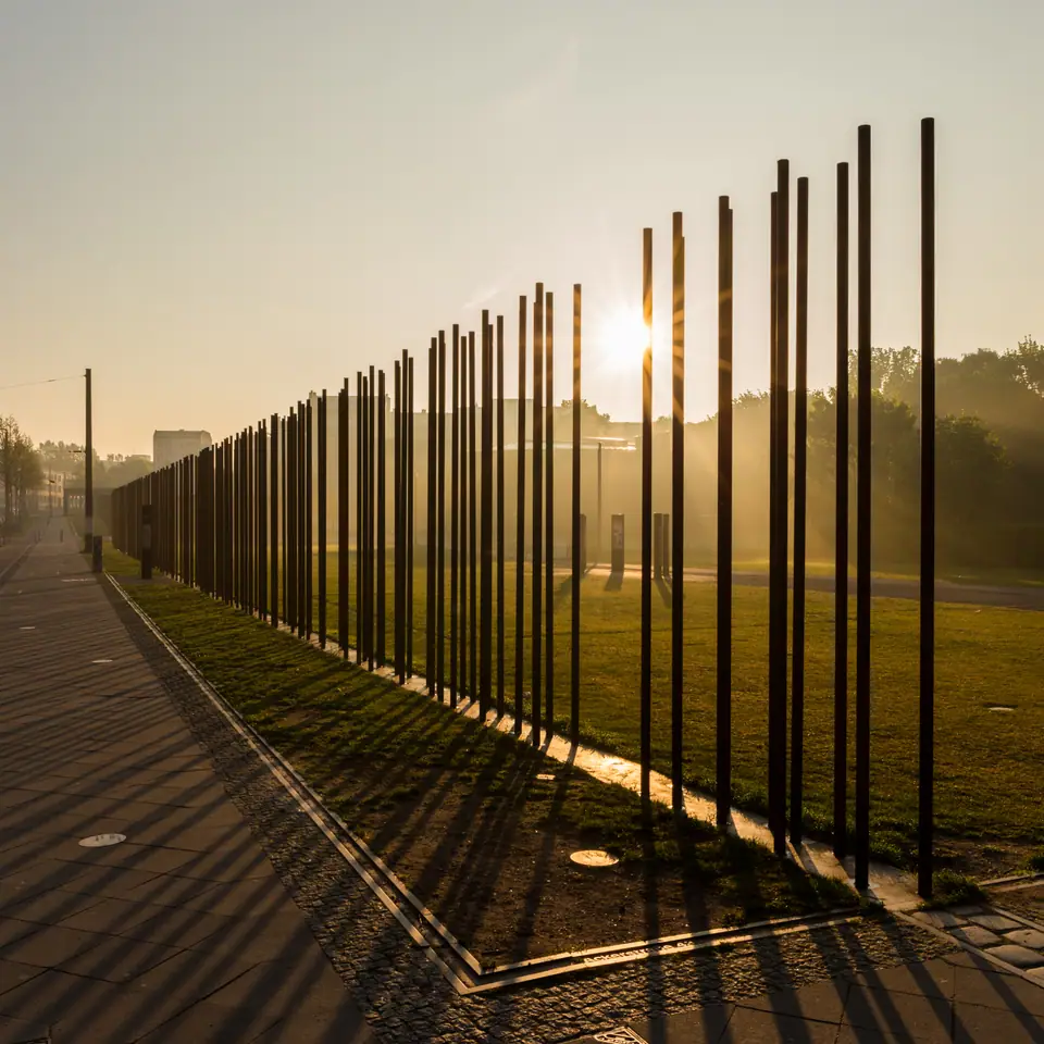 Fila de postes de acero de la Ventana de la Memoria en el Memorial del Muro de Berlín en Bernauer Straße, al amanecer