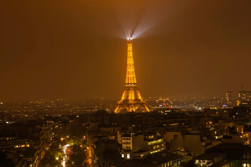 La Torre Eiffel iluminada de noche sobre el horizonte de París