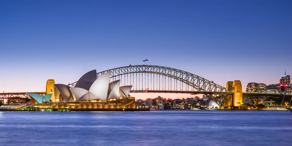 La Ópera de Sídney y el puente del puerto al atardecer, en Sídney, Australia