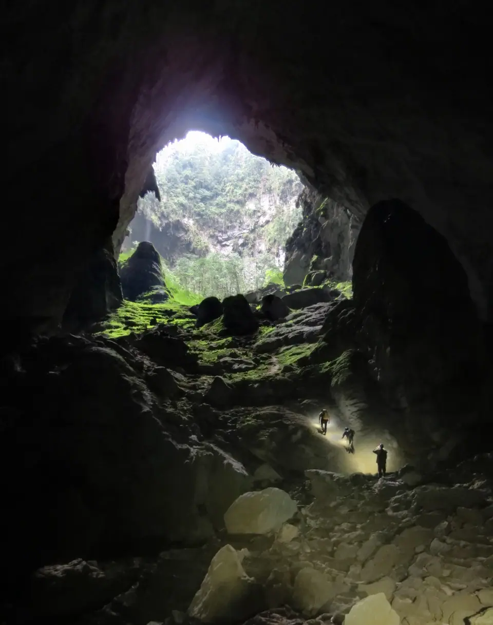 Entrada de la cueva Son Doong con luz natural y una persona para escala, Vietnam